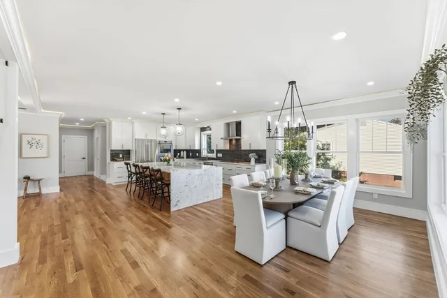 a living room with couches and kitchen view with wooden floor