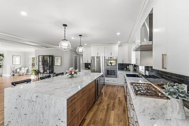 a large kitchen with kitchen island a large counter space a sink appliances and cabinets