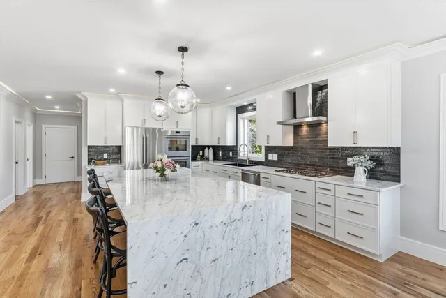a large kitchen with lots of counter space a sink appliances and cabinets