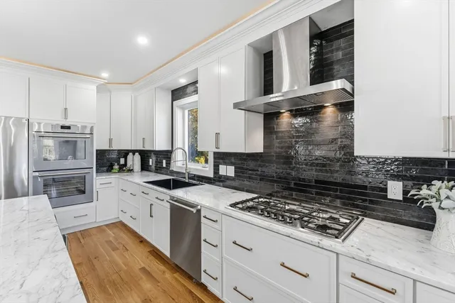 a kitchen with stainless steel appliances granite countertop a stove and a sink