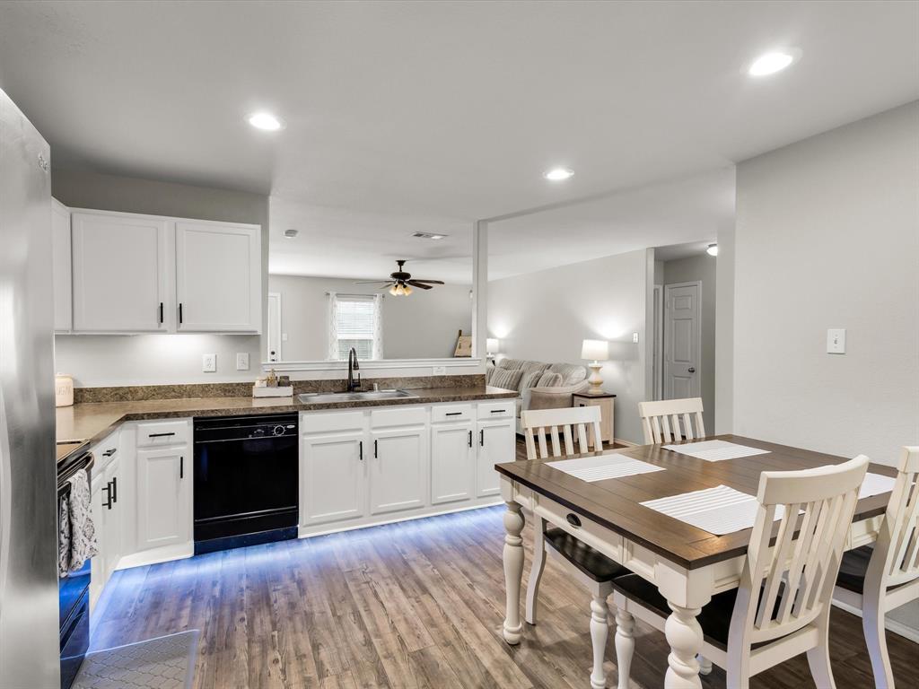 a kitchen with granite countertop sink stove and white cabinets