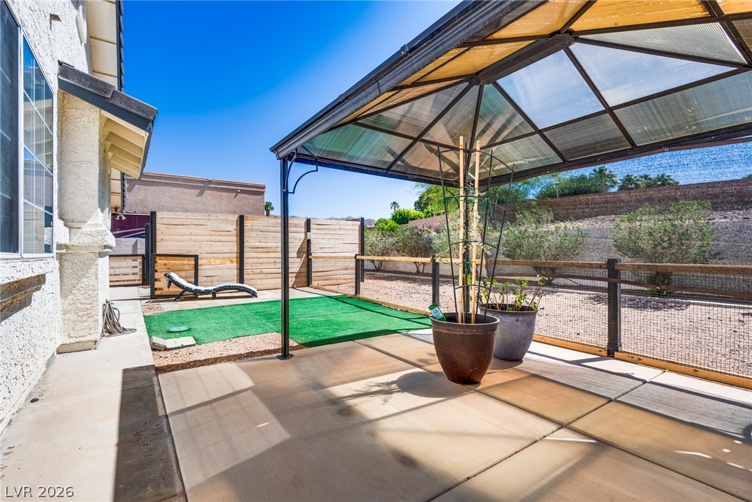 524 Swallow Cove Boulder City, NV 89005 - Photo 41 of 58 A tranquil outdoor space offers a covered patio and a neatly fenced yard for relaxation.