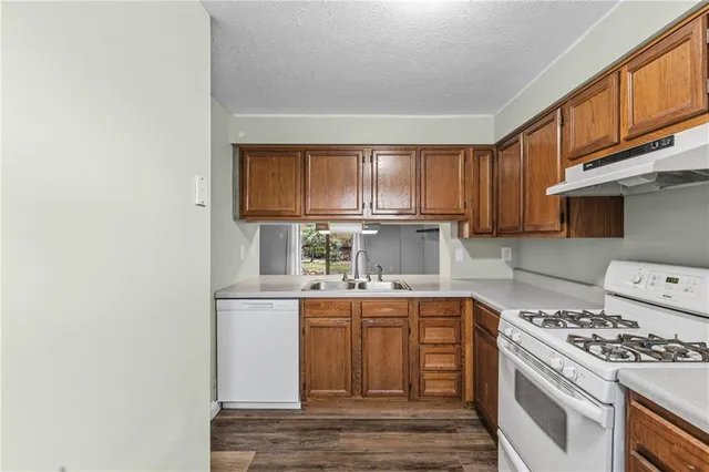 a kitchen with kitchen island granite countertop a sink cabinets stainless steel appliances and a counter space