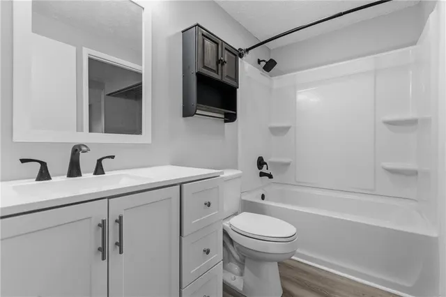 a bathroom with a toilet a sink a mirror a bathtub and shower