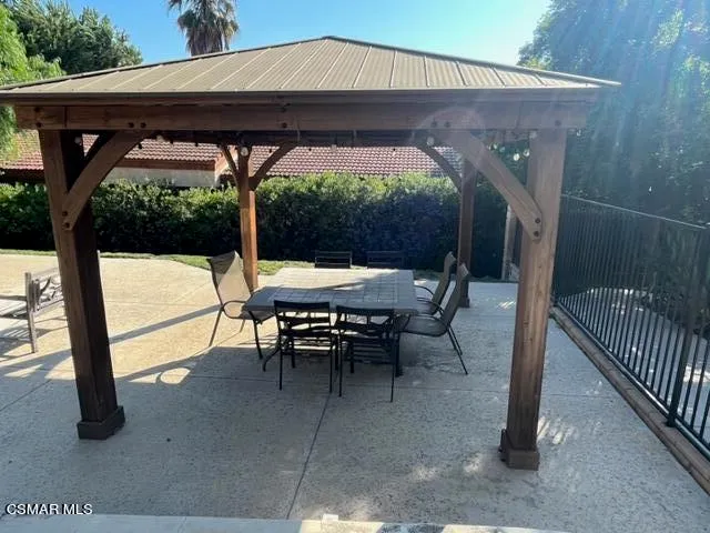 an outdoor sitting area with furniture and umbrella