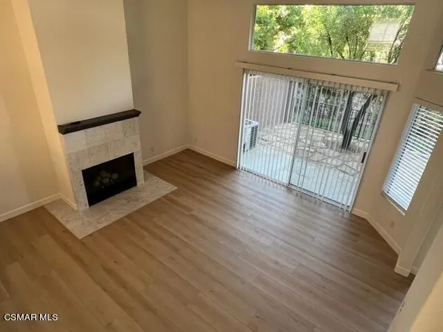 a view of a livingroom with wooden floor and a fireplace