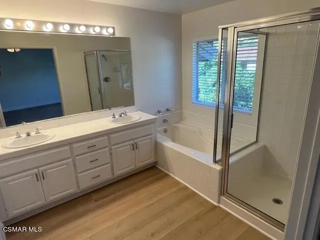 a spacious bathroom with a double vanity sink a mirror and a bathtub
