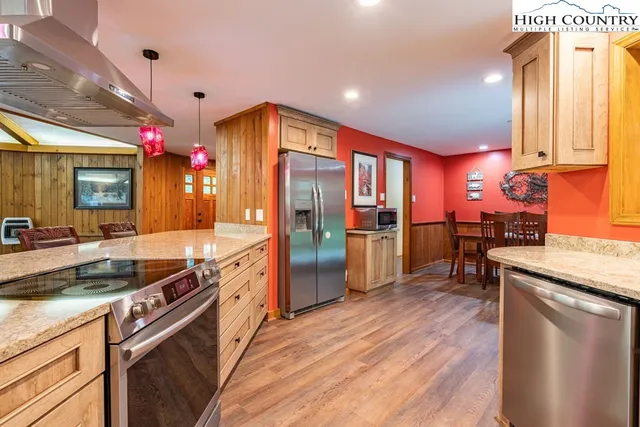 a kitchen with stainless steel appliances granite countertop a sink a stove and a refrigerator