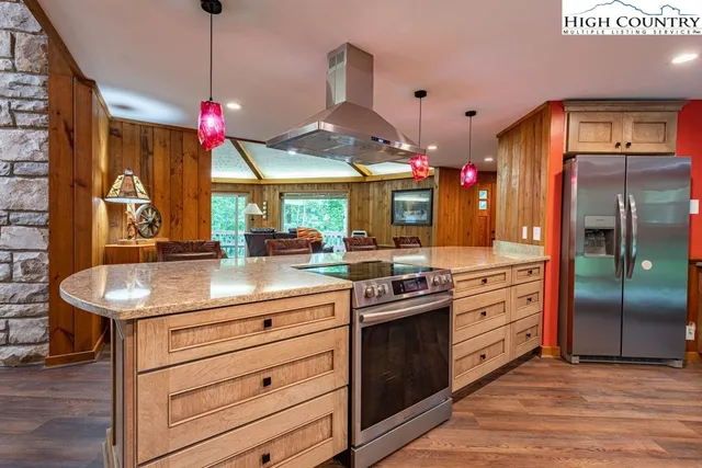 a kitchen with stainless steel appliances granite countertop a sink a stove and a refrigerator