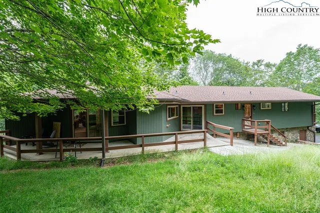 a view of a house with backyard and a tree