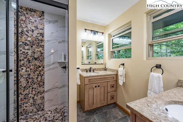 a bathroom with a granite countertop sink a toilet and shower