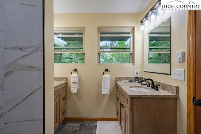 a bathroom with sink a mirror and a window