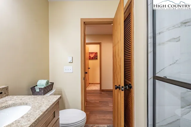 a bathroom with a granite countertop sink toilet and shower