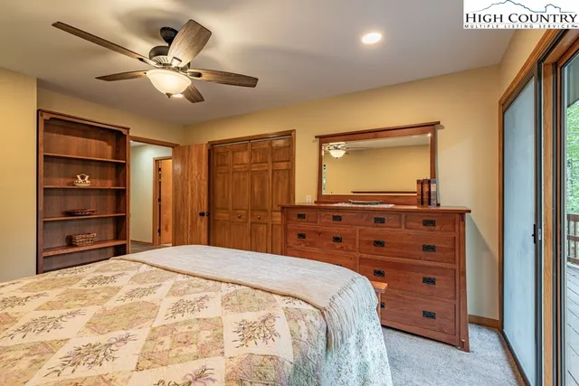 a bedroom with a bed and a dresser with mirror