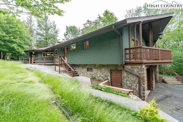 an aerial view of a house with a yard and large trees