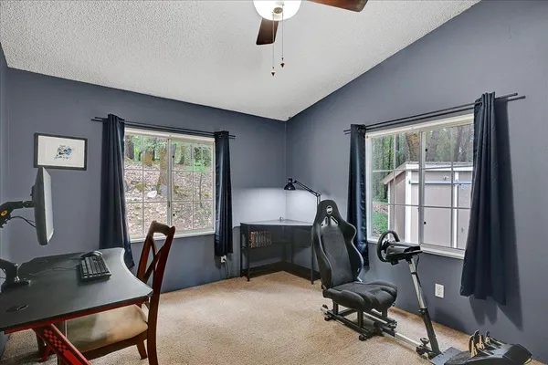 a view of a workspace with furniture and a window