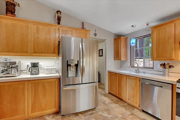 a kitchen with stainless steel appliances a refrigerator sink and cabinets