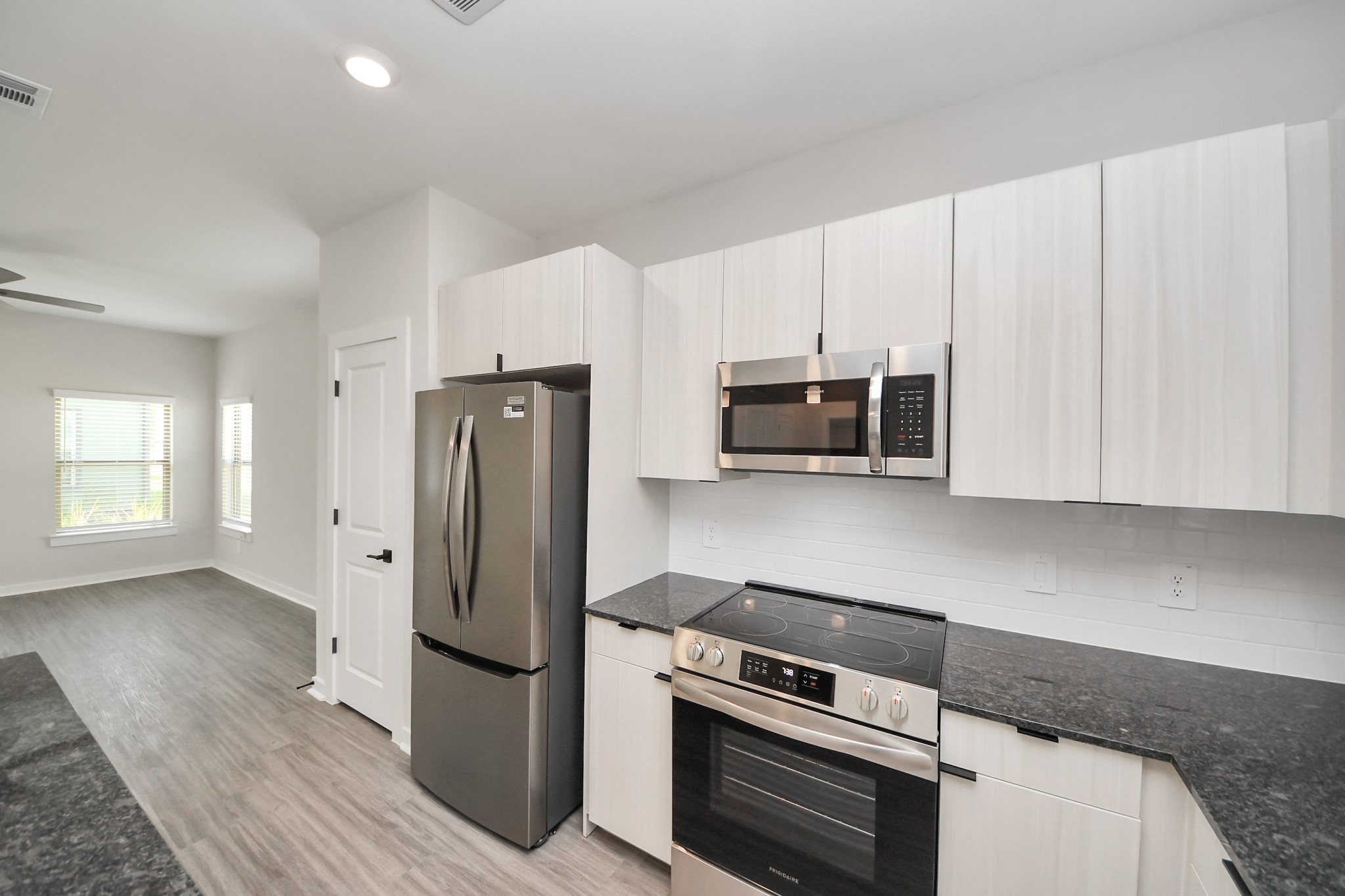 7711 Longmire Road, Unit 58 Conroe, TX 77304 - Photo 41 of 48 Boasting luxury finishes-stylish Island kitchen,granite counters,subway tile backsplash,ample custom cabinet space,stainless appliances,refrigerator,full size washer&dryer included,wood-like flooring throughout,open concept floor plan.