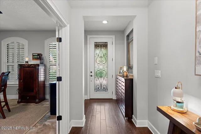 a living room with furniture kitchen view and a wooden floor