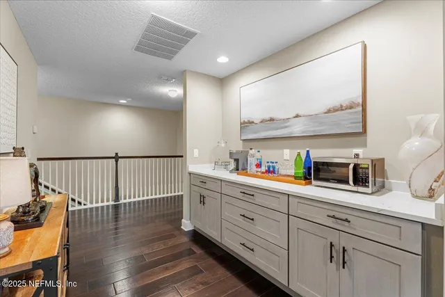 an aerial view of ocean and residential houses with outdoor space and swimming pool