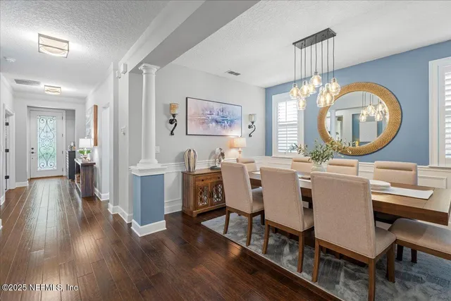 a living room with lots of furniture kitchen view and a wooden floor