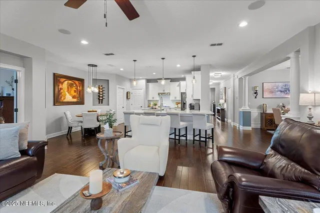 a large kitchen with kitchen island a dining table chairs and a wooden floor