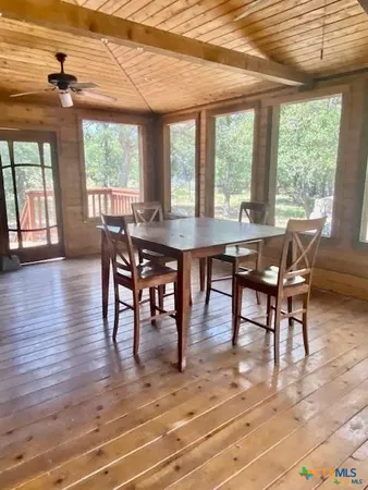 a view of a dining room with furniture large windows and wooden floor
