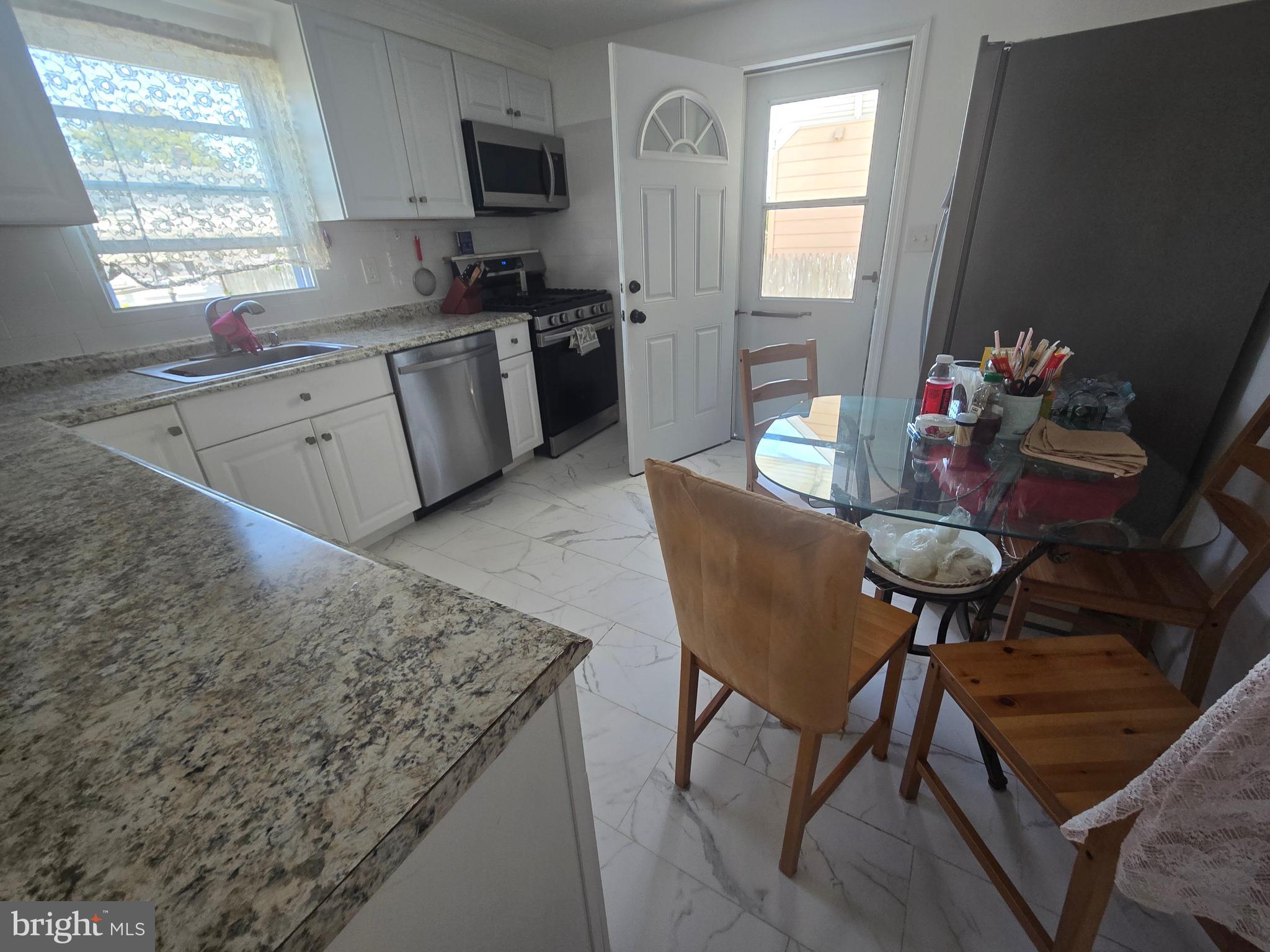 194 Atlantic Avenue Hamilton, NJ 08609 - Photo 19 of 43 a kitchen with stainless steel appliances granite countertop sink microwave and window