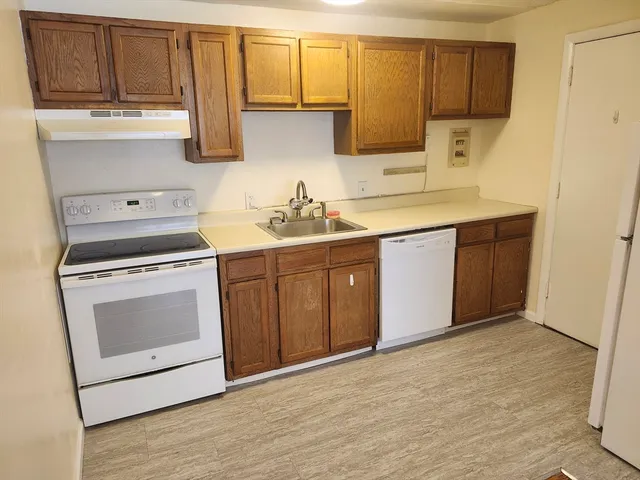 a kitchen with a stove sink and cabinets