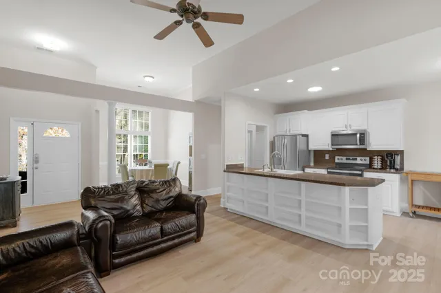 a living room with stainless steel appliances kitchen island granite countertop a couch and a view of living room