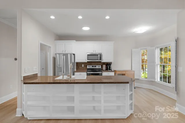 a kitchen with kitchen island a counter top space a sink and appliances