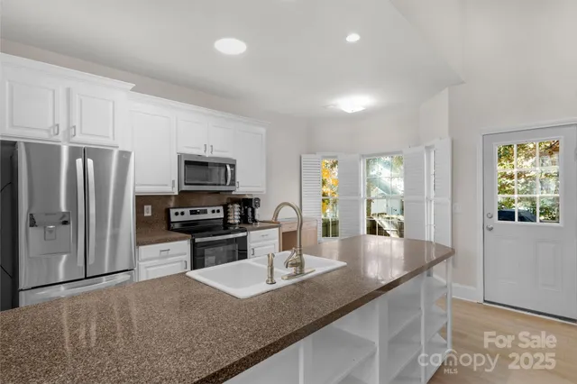a kitchen with stainless steel appliances granite countertop a sink refrigerator and microwave