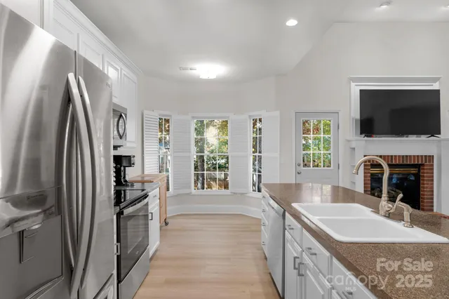 a large kitchen with granite countertop a large window and a refrigerator