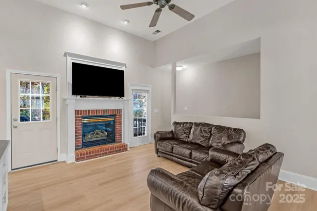 a living room with furniture a fireplace and a flat screen tv