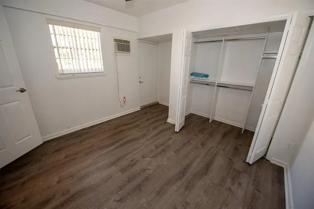 an empty room with wooden floor sink and closet