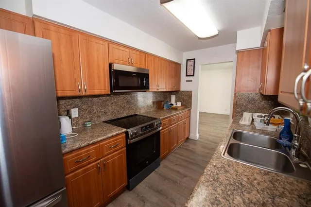 a kitchen that has a sink and a stove top oven