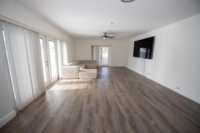 an empty room with wooden floor and windows
