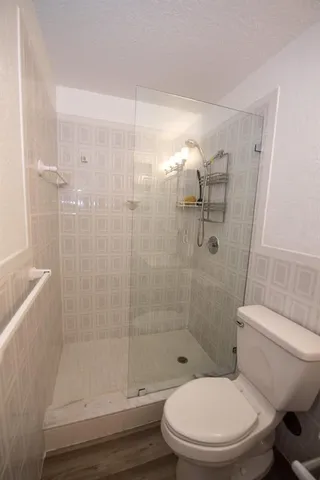 a white toilet next to a bathroom