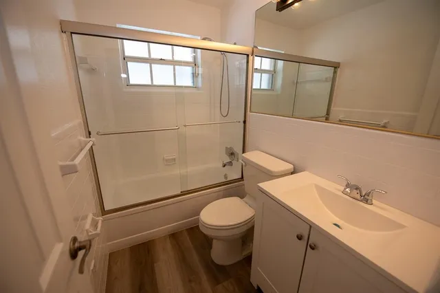 a bathroom with a sink a toilet and shower