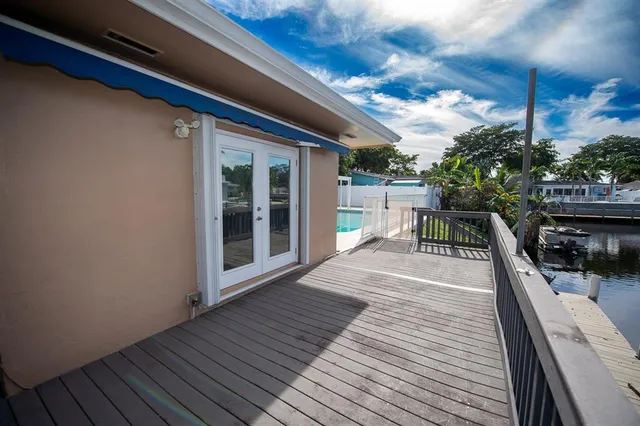 a view of a deck with a floor to ceiling window next to a yard
