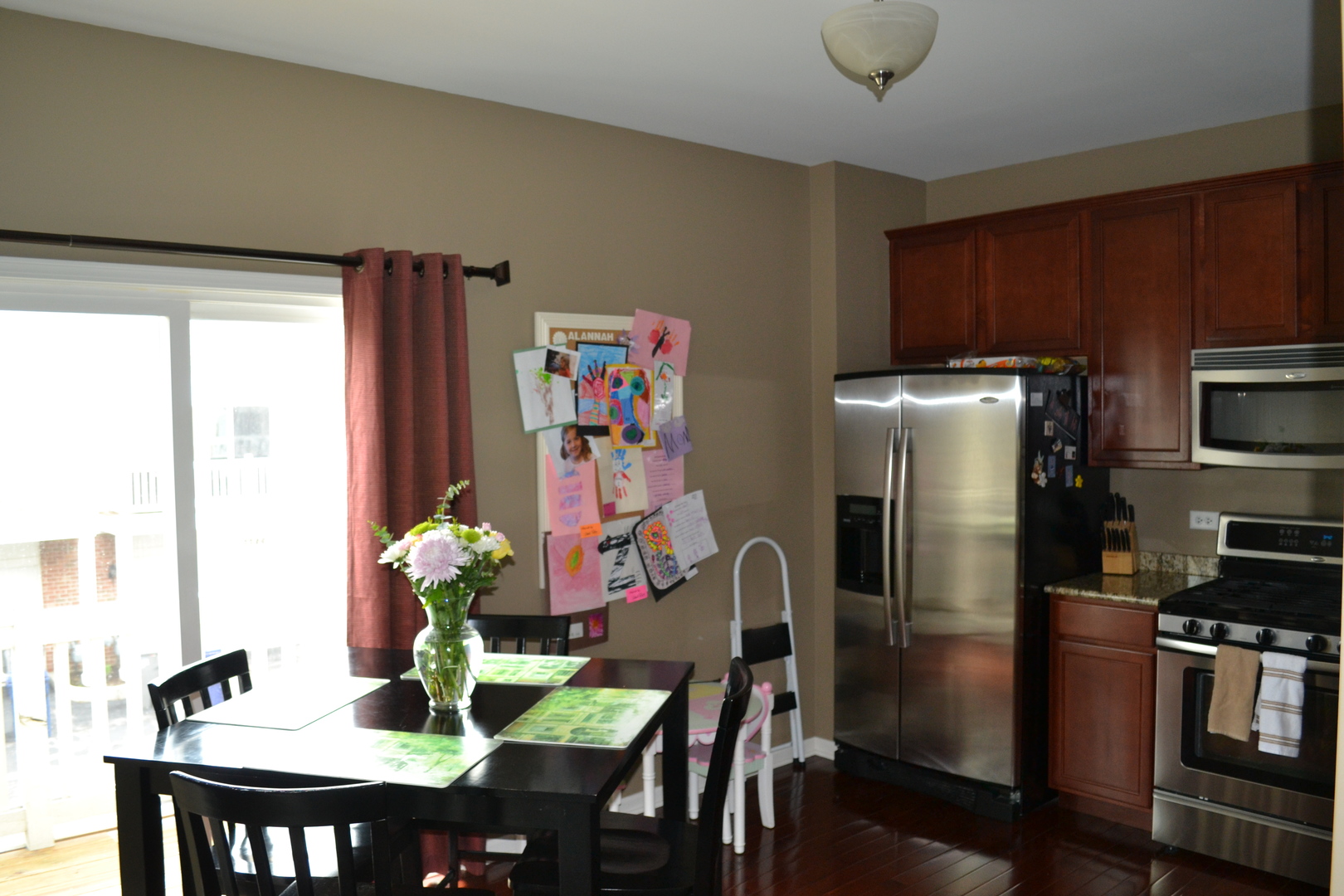 3372 Cameron Drive Elgin, IL 60124 - Photo 8 of 18 a dining room with furniture a kitchen view and a refrigerator