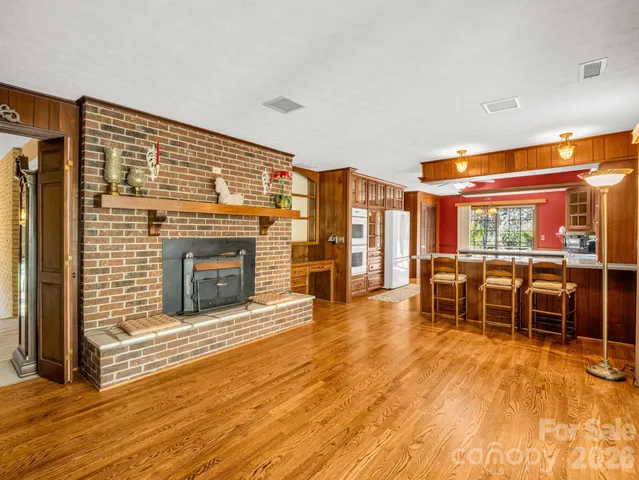 a living room with furniture a fireplace and wooden floor