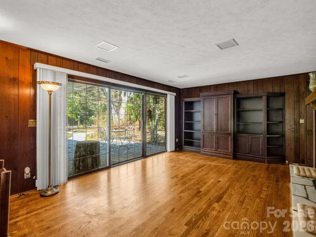 a view of an empty room with closet and windows