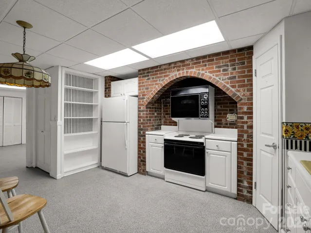 a view of kitchen with sink and refrigerator