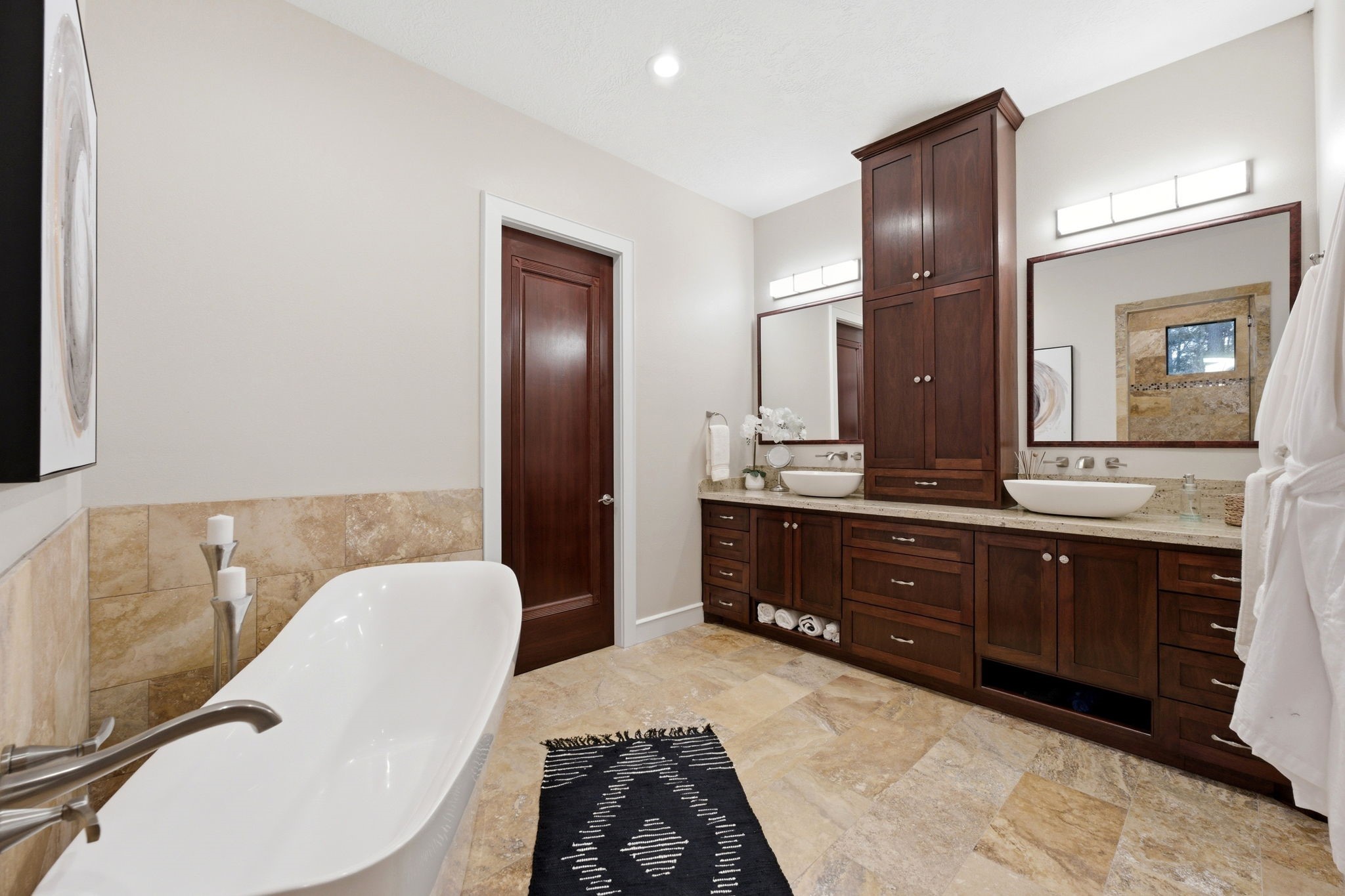 280 Sundog Road Huntsville, TX 77340 - Photo 24 of 50 Spa-inspired primary bathroom featuring a beautiful freestanding soaking tub, dual sinks set in a custom vanity with generous storage, and elegant travertine flooring and tile.
