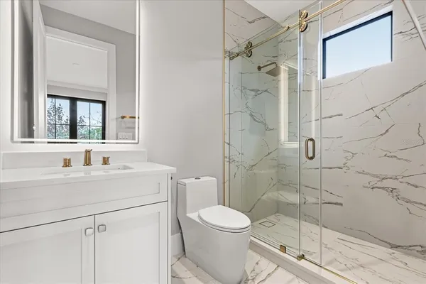 a bathroom with a sink a toilet and shower