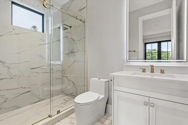 a bathroom with a toilet a sink a vanity and mirror