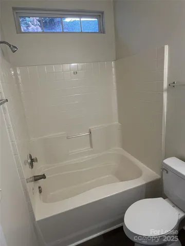 a white toilet and tub sitting next to a bathroom sink