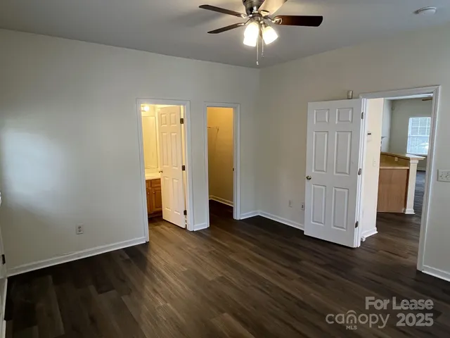 an empty room with wooden floor and closet area