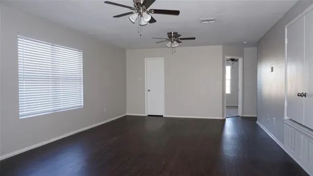 a view of a room with a hardwood floor and a ceiling fan